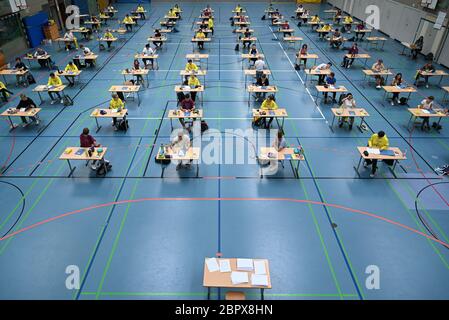 Ravensburg, Allemagne. 20 mai 2020. Pendant l'examen allemand Abitur, les élèves s'assoient dans la salle de sport du Albert-Einstein-Gymnasium à la distance prescrite l'un de l'autre avant leurs tâches d'examen. Environ 80 élèves suivent l'examen allemand Abitur au Albert-Einstein-Gymnasium. Credit: Felix Kästle/dpa/Alay Live News Banque D'Images