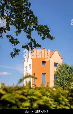 Petit logement résidentiel moderne construit sur d'autres maisons dans un pays-Bas. Façades aux couleurs chaudes de différentes teintes. Architecte géométrique Banque D'Images