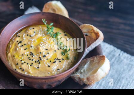 Bol de l'hummus de citrouille avec des tranches de pain grillé Banque D'Images