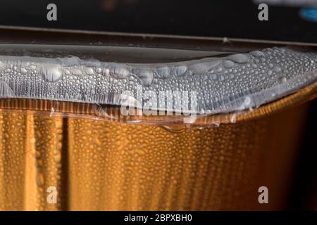 Décongeler le repas dans du papier aluminium avec de la condensation sur la surface de la grenaille Banque D'Images
