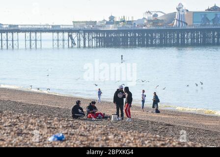 Brighton UK 20 mai 2020 - les visiteurs de leurs 20 se rassemblent sur Brighton Beach ce matin par temps chaud et ensoleillé, car les températures devraient atteindre les 20 heures élevées dans certaines parties de la Grande-Bretagne aujourd'hui pendant la crise pandémique du coronavirus COVID-19 . Crédit : Simon Dack / Alamy Live News Banque D'Images