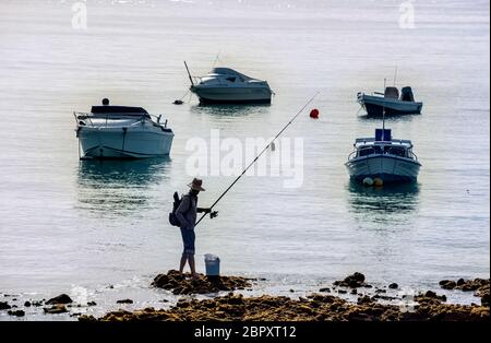 Homme pêche dans la zone portuaire de Corralejo, îles Canaries Banque D'Images