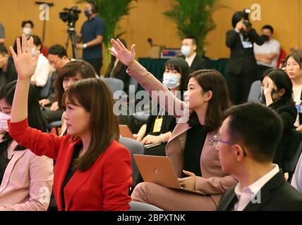 (200520) -- BEIJING, 20 mai 2020 (Xinhua) -- des journalistes lèvent la main pour poser des questions lors d'une conférence de presse de la troisième session du Comité national de la 13ème Conférence consultative politique populaire chinoise (CPPCC) par liaison vidéo à Beijing, capitale de la Chine, le 20 mai 2020. Le Comité national de la CPPCC a tenu une conférence de presse mercredi après-midi, avant la session annuelle de l'organe consultatif politique supérieur. Guo Weimin, porte-parole de la troisième session du 13ème Comité national du CPPCC, a informé les médias de la session et a répondu aux questions par liaison vidéo en raison de l'epid Banque D'Images
