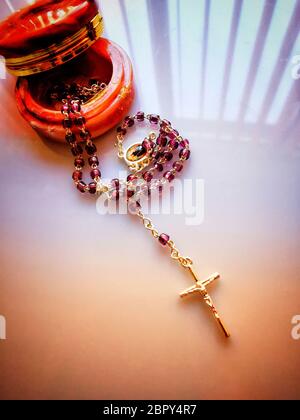 Collier croisé avec perles rouges sur une boîte sur la table sous les lumières Banque D'Images