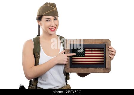 Jolie jeune femme en uniforme ww2-nous montrant un drapeau américain Banque D'Images