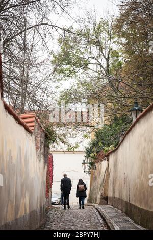 Formes de personnes marchant dans la rue Novy Svet, une rue pavée vide médiévale et étroite de la colline de Hradcany à Prague, République tchèque, avec médiévale Banque D'Images