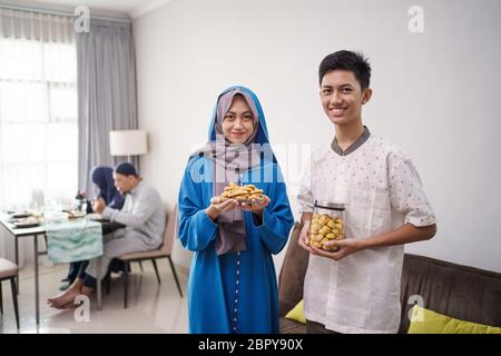 jeune garçon et fille musulmans souriant à la caméra tout en tenant le gâteau. eid mubarak festival Banque D'Images