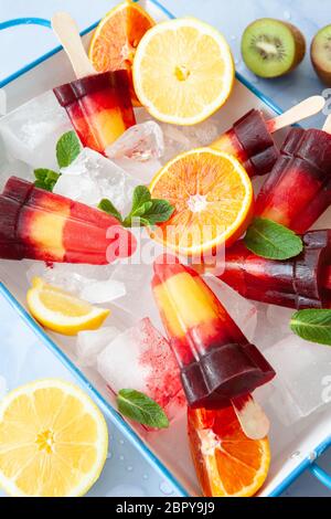 Sucettes de glace couleur fruitée avec une variété de fruits frais Banque D'Images