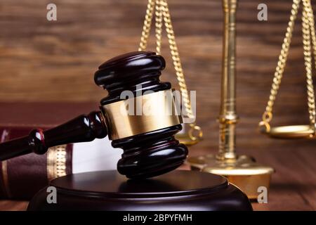 Close-up of Gavel en face de la Justice sur l'échelle d'un bureau en bois Banque D'Images