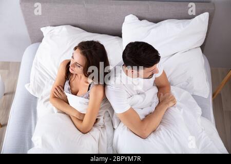 Vue de dessus du couple marié désespéré dos à dos sur le lit Banque D'Images