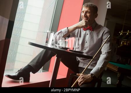 Le joueur de billard souriant joueur de billard joueur de billard est en train de prendre une pause-café dans le club de billard. Banque D'Images