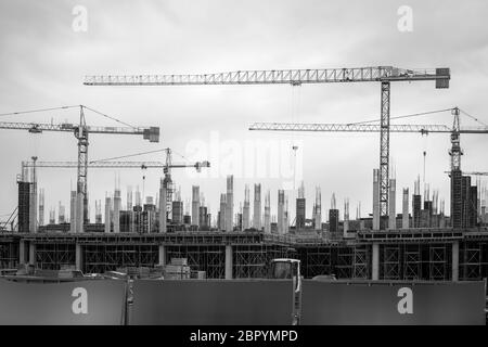 Photo en noir et blanc des grues dans l'industrie de la construction. Banque D'Images