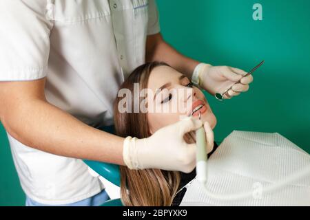 Le dentiste enlève le tartre des dents de son patient Banque D'Images