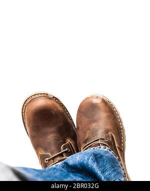 Bottes brunes et jeans bleus pour hommes. Isolé sur bacille blanc Banque D'Images