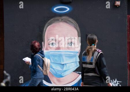 Manchester, Grande-Bretagne. 19 mai 2020. Des gens marchent devant une fresque d'un artiste de rue représentant Debra Williams, un praticien de service d'exploitation à l'infirmerie royale de Manchester, à Manchester, en Grande-Bretagne, le 19 mai 2020. Crédit : Jon Super/Xinhua/Alay Live News Banque D'Images