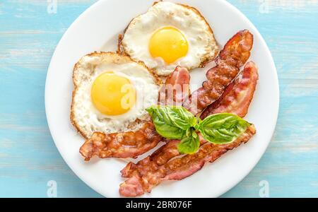 Oeufs au plat avec du bacon sur la table en bois Banque D'Images