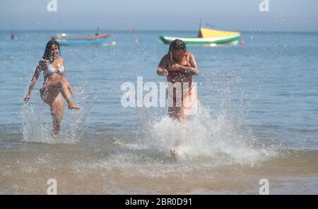 Sorrell Vince, 23 (à droite) de Northampton et Bethany Heatley de Preston en profitant du soleil sur la plage de Cullercoats, Tynemouth, alors que les gens affluent vers les parcs et les plages avec des mesures d'isolement assouplies. Banque D'Images