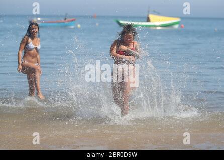 Sorrell Vince, 23 (à droite) de Northampton et Bethany Heatley de Preston en profitant du soleil sur la plage de Cullercoats, Tynemouth, alors que les gens affluent vers les parcs et les plages avec des mesures d'isolement assouplies. Banque D'Images