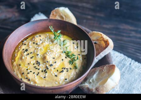 Bol de l'hummus de citrouille avec des tranches de pain grillé Banque D'Images