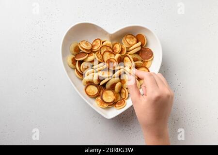 Petites crêpes tendance pour enfant en forme d'assiette de coeur sur fond blanc. Vue de dessus. Banque D'Images