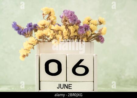 Calendrier blanc en cubes pour juin décoré de fleurs sur fond vert avec espace copie Banque D'Images