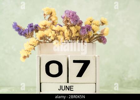 Calendrier blanc en cubes pour juin décoré de fleurs sur fond vert avec espace copie Banque D'Images