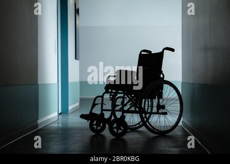 Silhouette de fauteuil roulant vide stationné dans un couloir de l'hôpital Banque D'Images