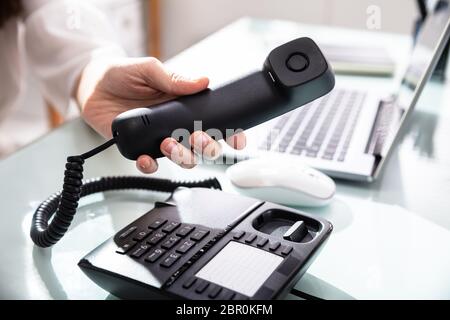 Close-up of a woman's Hand composant le numéro de téléphone à appeler dans Office Banque D'Images