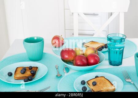 Plats et tasses turquoise élégants dans la cuisine moderne. Beaucoup d'accessoires turquoise. Petit déjeuner savoureux, couleurs vives. Banque D'Images