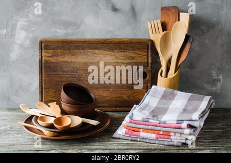 De simples ustensiles de cuisine : plaques en céramique rustique en bois ou bambou, couverts, serviettes et planche à découper vintage dans l'intérieur de la cuisine. Style rustique. Accueil Kitch Banque D'Images