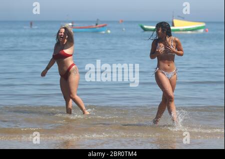 Sorrell Vince, 23 (à droite) de Northampton et Bethany Heatley de Preston en profitant du soleil sur la plage de Cullercoats, Tynemouth, alors que les gens affluent vers les parcs et les plages avec des mesures d'isolement assouplies. Banque D'Images