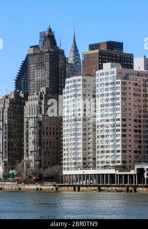 La couronne du Chrysler Building se trouve derrière les bâtiments de la rivière East River, à New York, aux États-Unis Banque D'Images