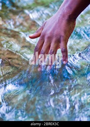 L'eau, source de vie, et de la main d'un jeune garçon Banque D'Images