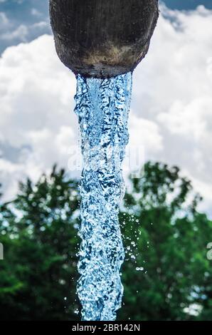 L'eau, source de vie, descend frais et propre du bleu ciel vers la montagne et vers la vallée Banque D'Images