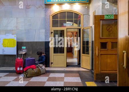 Gare de Kazansky, Moscou, Russie: Petite passager assis avec ses valises près de la petite église orthodoxe à la gare de Kazansky Banque D'Images