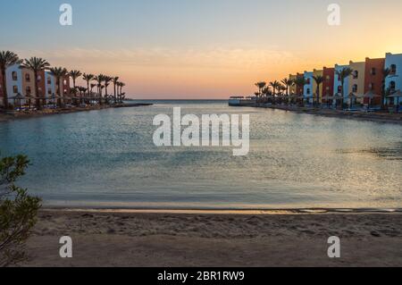 Vue d'une lagune de la mer Rouge au lever du soleil entre deux rangées de chambre d'hôtel à Hurghada Banque D'Images