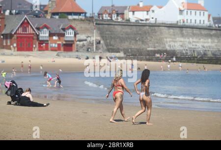 Sorrell Vince, 23 (à gauche) de Northampton et Bethany Heatley de Preston en profitant du soleil sur la plage de Cullercoats, Tynemouth, alors que les gens affluent vers les parcs et les plages avec des mesures d'isolement assouplies. Banque D'Images