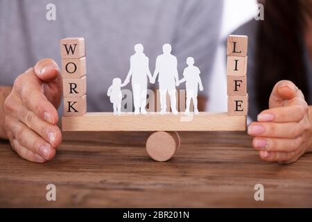 La protection du travail et de la vie de couple avec la famille l'équilibre permanent entre les chiffres sur Seesaw Banque D'Images