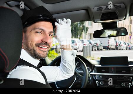 Portrait d'un homme heureux voiture avec chauffeur assis à l'intérieur Banque D'Images