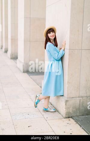Belle jeune femme rouge à cheveux en robe bleue debout près des colonnes à Paris. Belle fille touristique à pied et profiter de vacances dans l'ancien Banque D'Images