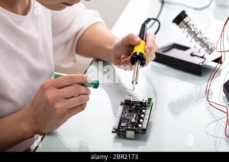 Ingénieur femelle ou réparations Tech appareil électronique dans l'atelier de réparation du matériel Banque D'Images