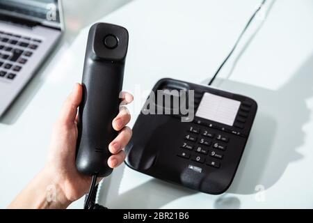 Close-up of a woman's Hand composant le numéro de téléphone à appeler dans Office Banque D'Images