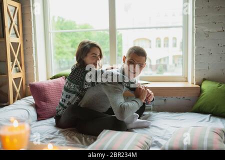 Les oreillers se battent, s'amuser. Quarantaine verrouillage, séjour à la maison concept - jeune beau couple appréciant un nouveau style de vie pendant le coronavirus urgence sanitaire mondiale. Bonheur, ensemble, santé. Banque D'Images