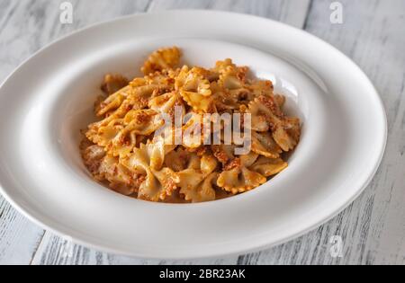 Partie de farfalle avec pesto aux tomates séchées sur la table en bois blanc Banque D'Images