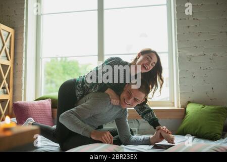 Les oreillers se battent, s'amuser. Quarantaine verrouillage, séjour à la maison concept - jeune beau couple appréciant un nouveau style de vie pendant le coronavirus urgence sanitaire mondiale. Bonheur, ensemble, santé. Banque D'Images