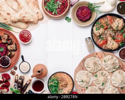 Vue depuis le dessus de la cuisine géorgienne sur une table blanchie à la chaux. Cuisine géorgienne traditionnelle - khinkali, kharcho, chahokhbili, phali, lobio et sauces locales - tkemali Banque D'Images