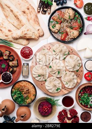 Vue depuis le dessus de la cuisine géorgienne sur une table en bois blanc. Cuisine et cuisine géorgiennes traditionnelles : khinkali, kharcho, chahokhbili, phali, lobio et sa locale Banque D'Images