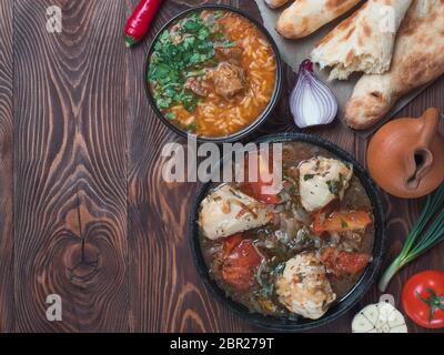 Cuisine géorgienne traditionnelle - soupe de Kharcho épicée et poulet Chachochbili, pain traditionnel Shotis Puri, pot à vin d'époque, légumes frais sur la courde Banque D'Images