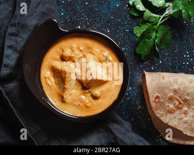 Masala de beurre de paneer indien dans un bol noir sur fond sombre. Shahi paneer beurre masala ou fromage cottage curry vue de dessus. Le paneer Shahi est le popula Banque D'Images