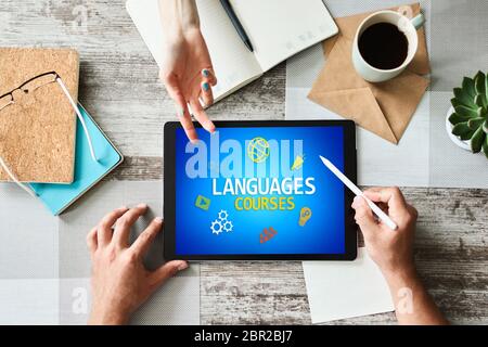 Tablette avec langues pour le texte et les icônes de cours à l'écran. Apprentissage de l'anglais en ligne. Concept d'éducation Banque D'Images